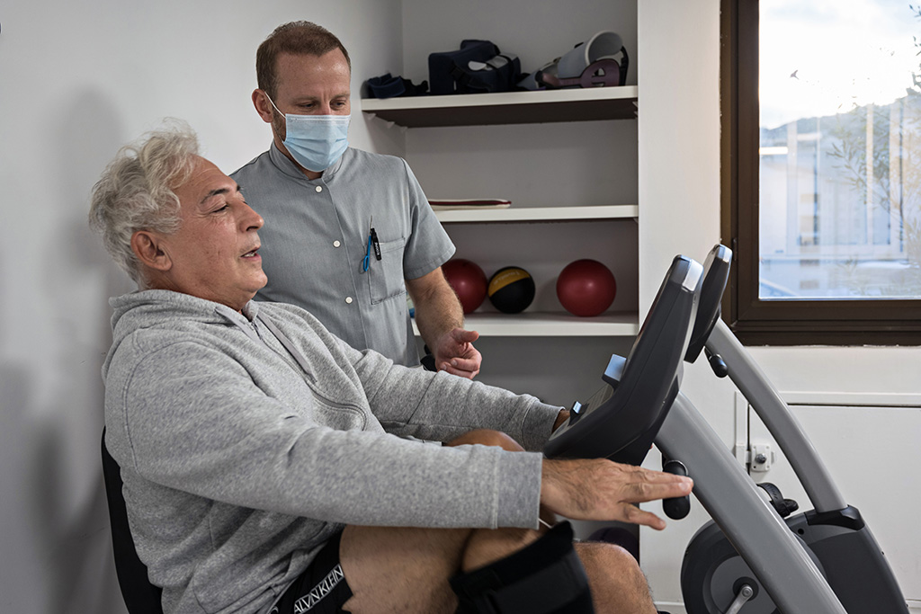 Kinésithérapeute accompagnant un patient en rééducation