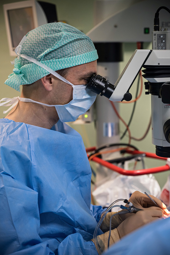 Chirurgien au microscope opératoire pendant une intervention